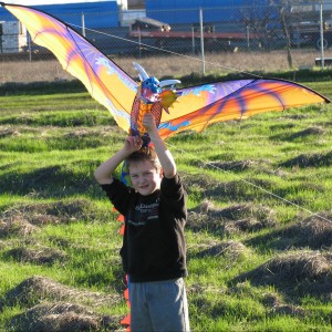 my little boy,johnny (squinting from sun) flying his kite